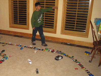 Picture of Nicholas with some of his cars, trucks, and planes